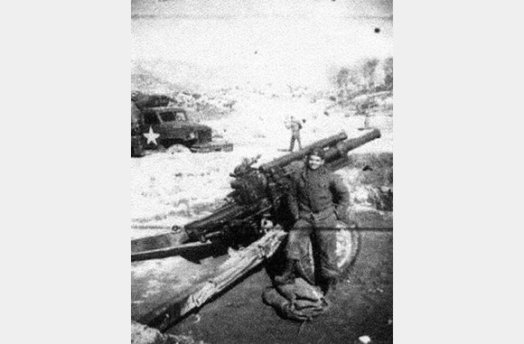 Mst.Sgt. Cristobal Melendez Claudio standing next to 105mm Howitzer - North Korea - April 19, 1951