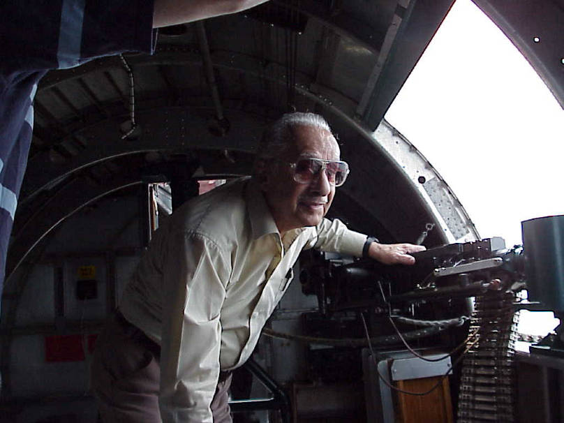 Clement Resto standing near waist gun of B17 "Sentimental Journey" at air show in Westchester County.